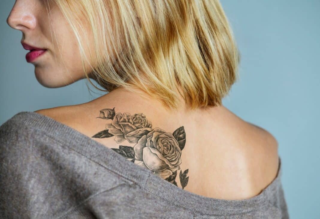 Femme avec un tatouage de rose sur l'épaule